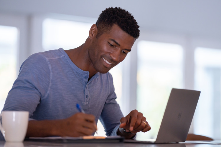 Young adult male working off of a laptop 