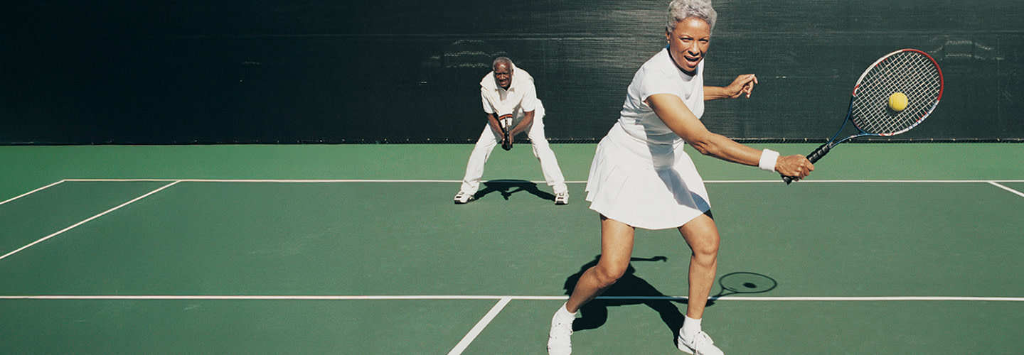 Elderly couple playing tennis