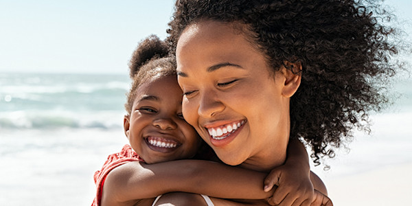 Woman carrying daughter on piggy back
