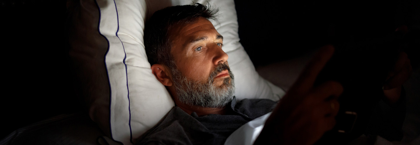 Hombre usando pantallas en la noche