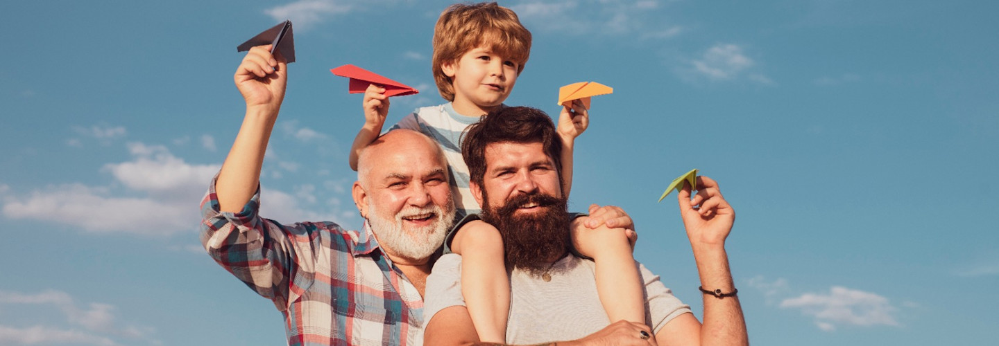 Generación de tres hombres. Abuelo, padre e hijo se abrazan y se divierten juntos.