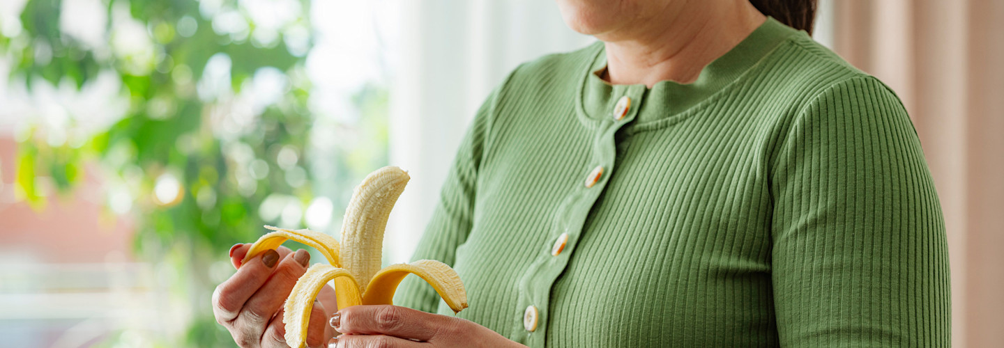 Mujer comiendo una banana