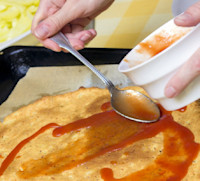Rocía la salsa de tomate en la cubierta y espolvorea con orégano. 