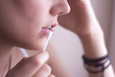 People with oral herpes outbreaks should avoid contact with the mouth and genital area of other people and not share items that come in contact with saliva. Condoms can help prevent transmission, although it only reduces the risk of infection. Episodes of genital herpes can occur in unprotected areas. For this reason, sex should be avoided when blisters are present. 