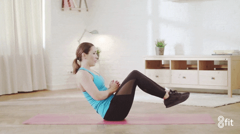 Core workouts at home: woman doing russian twists GIF