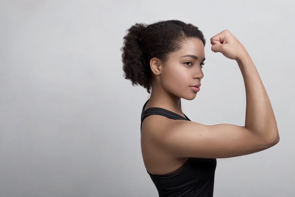 woman flexing her arm: showing how to lose fat and gain muscle
