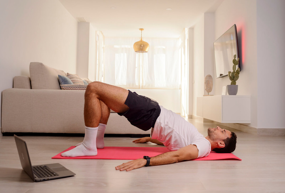 Man doing glute bridges at home
