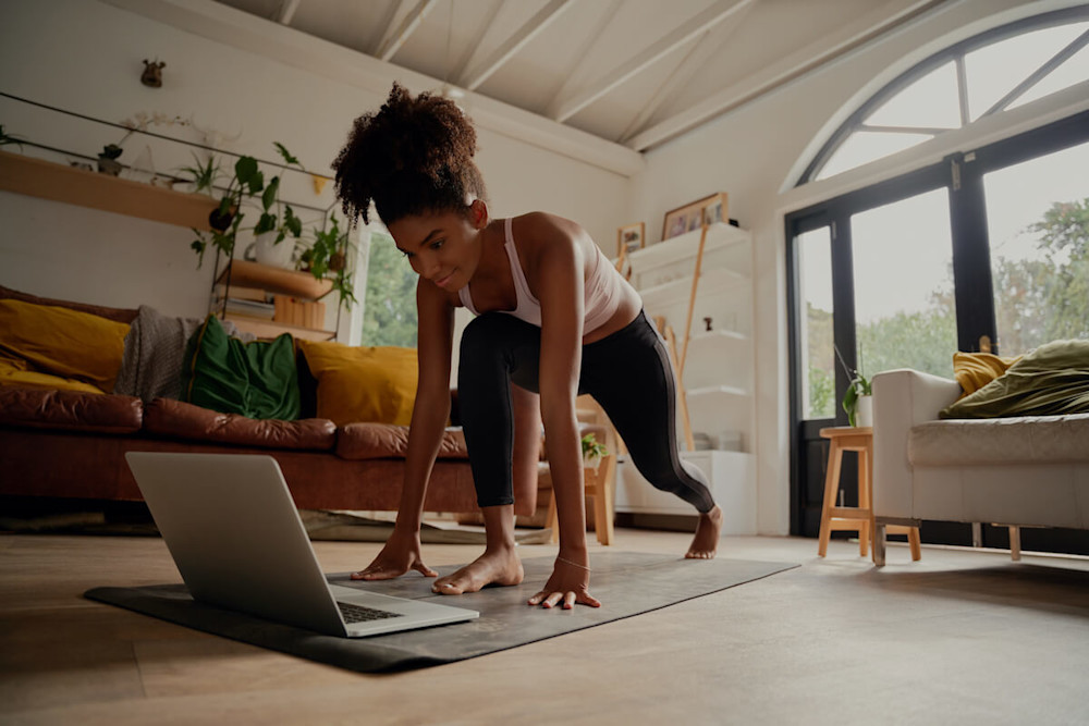 HIIT Workouts for Women: woman exercising at home following a video
