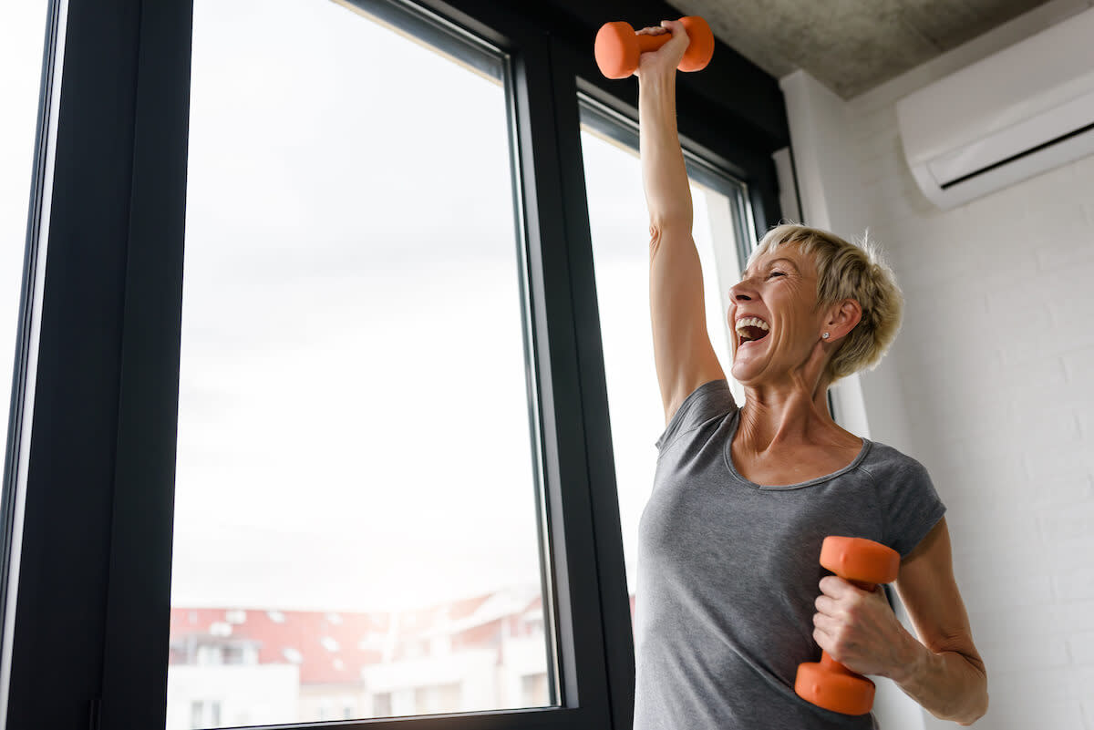 Functional fitness: senior woman working out using dumbbells