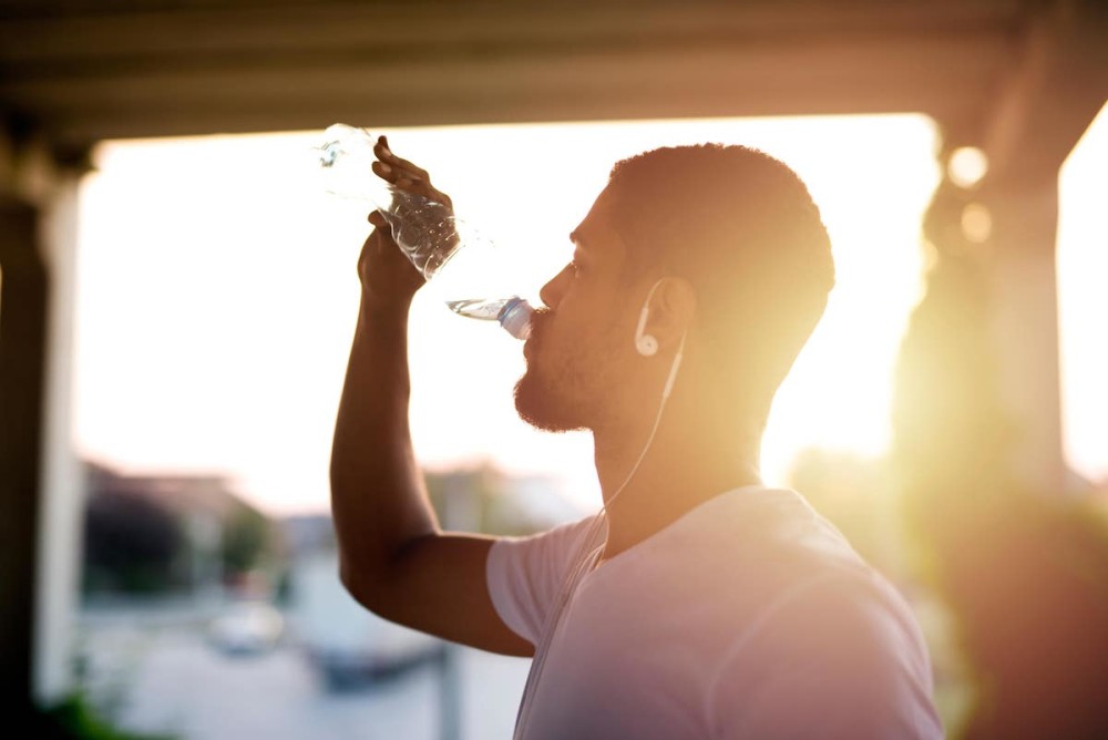 man drinking plenty of water