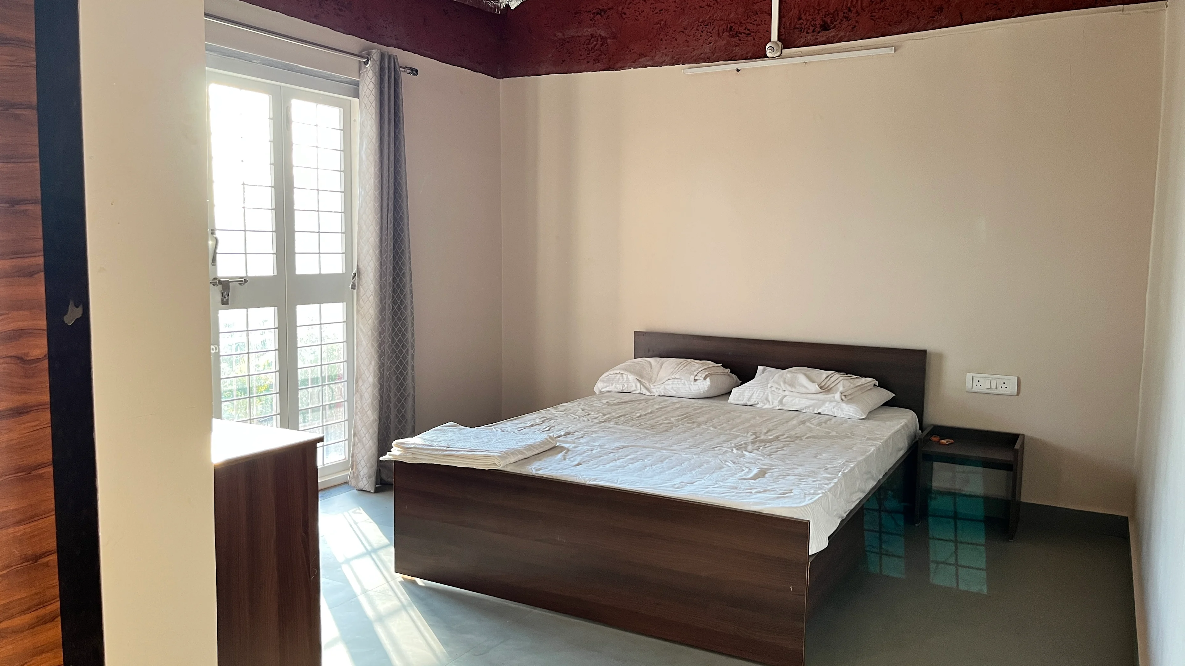 Primary suite bedroom at Blossom Retreat farmstay — comfortable accommodation in Chiplun, Maharashtra