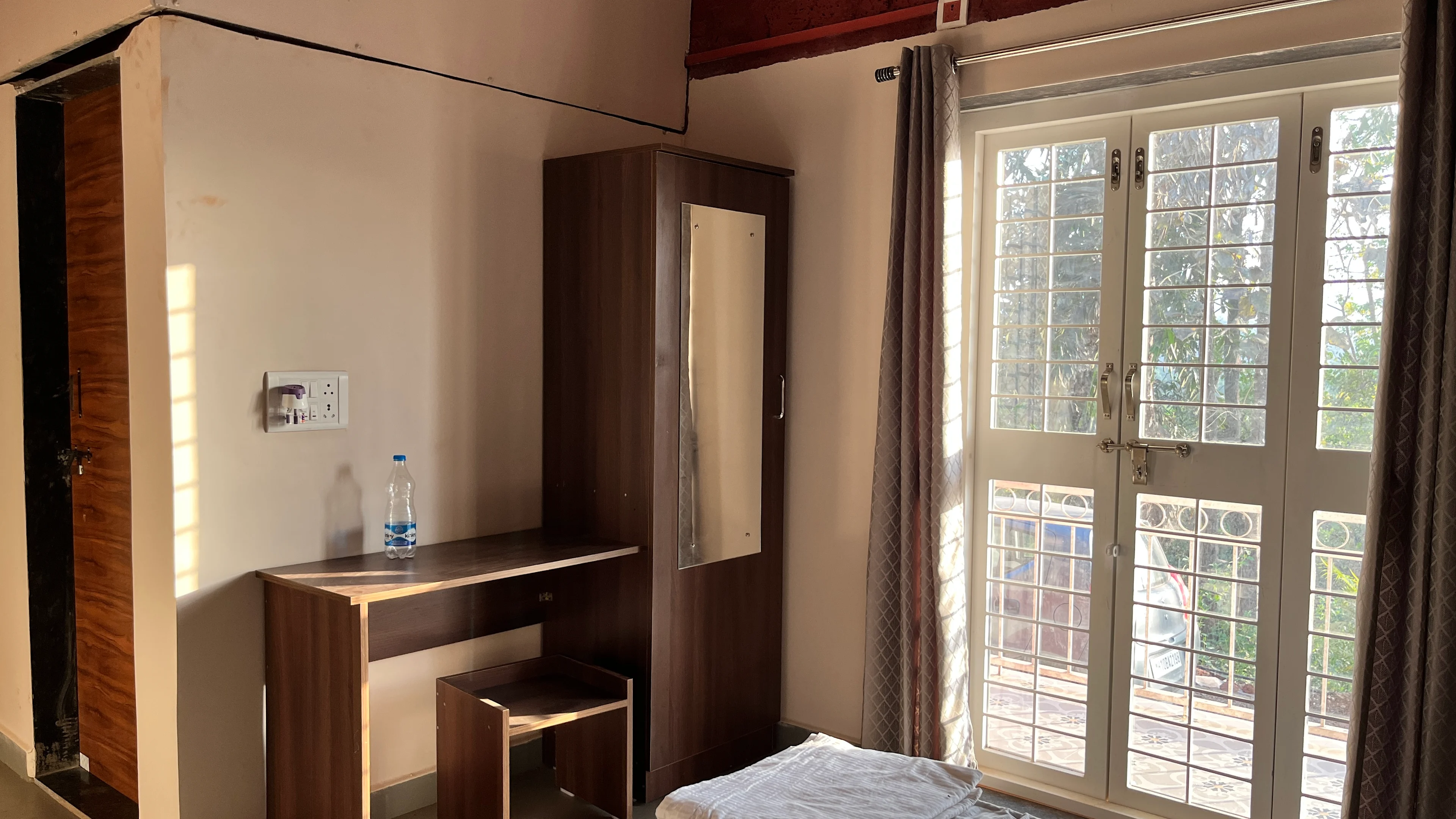 Garden-facing bedroom with natural light at Blossom Retreat wellness farmstay, Konkan coast