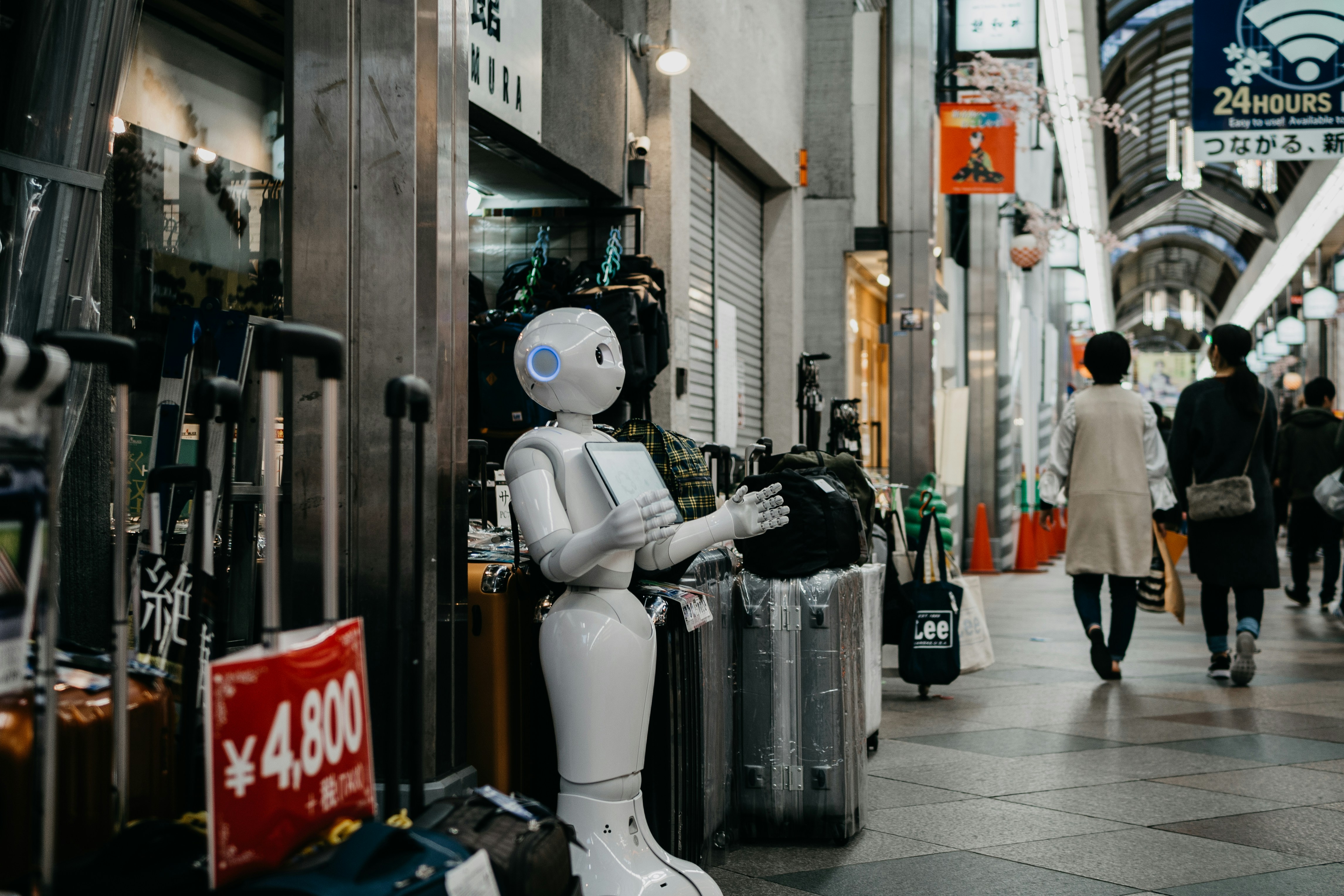 Humanoid robot engaging with shoppers in a busy market, illustrating AI technology and automation in real-world environments for AI SEO insights.