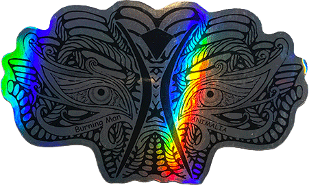 Holographic sticker showing two mirrored animal faces with a rainbow light streak and small text reading “Burning Man” and “Animalia.”