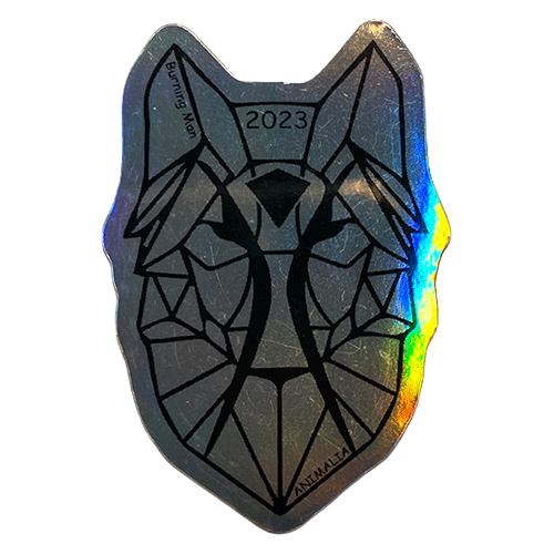 Silver holographic sticker with a geometric wolf face and “2023” at the top, reflecting rainbow light.