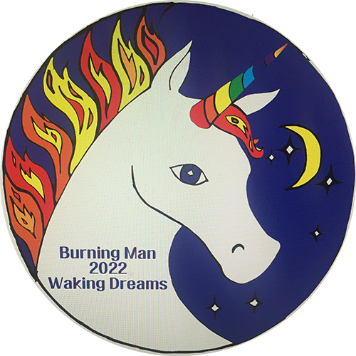 Circular sticker. Unicorn split: flaming mane on left (day), crescent moon and stars on right (night). Rainbow horn. Burning Man 2022 Waking Dreams.