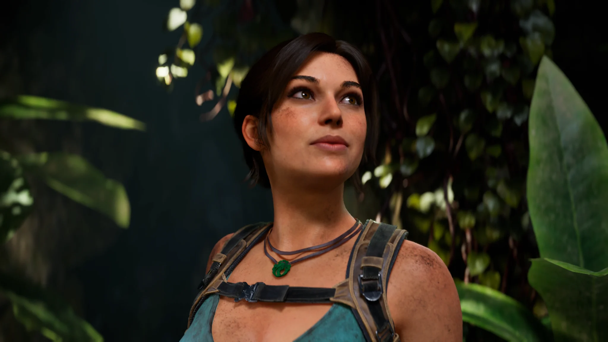 Lara Croft in jungle setting, looking upward with determined expression. Wearing tank top and green pendant. Lush tropical foliage background. Cinematic moment.