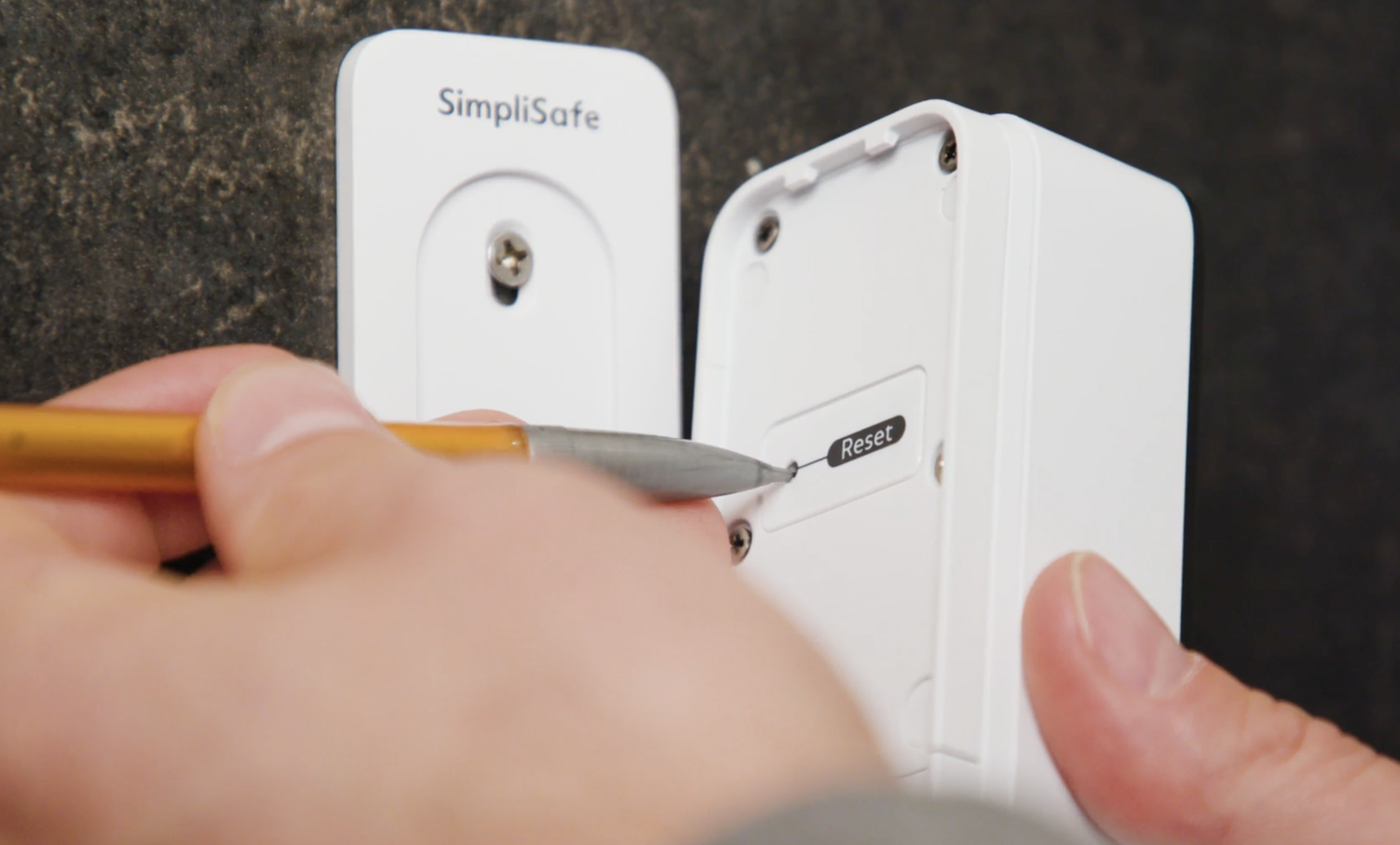 A mechanical pencil being used to press and hold the pinhole button located on the back of the Video Doorbell Series 2.