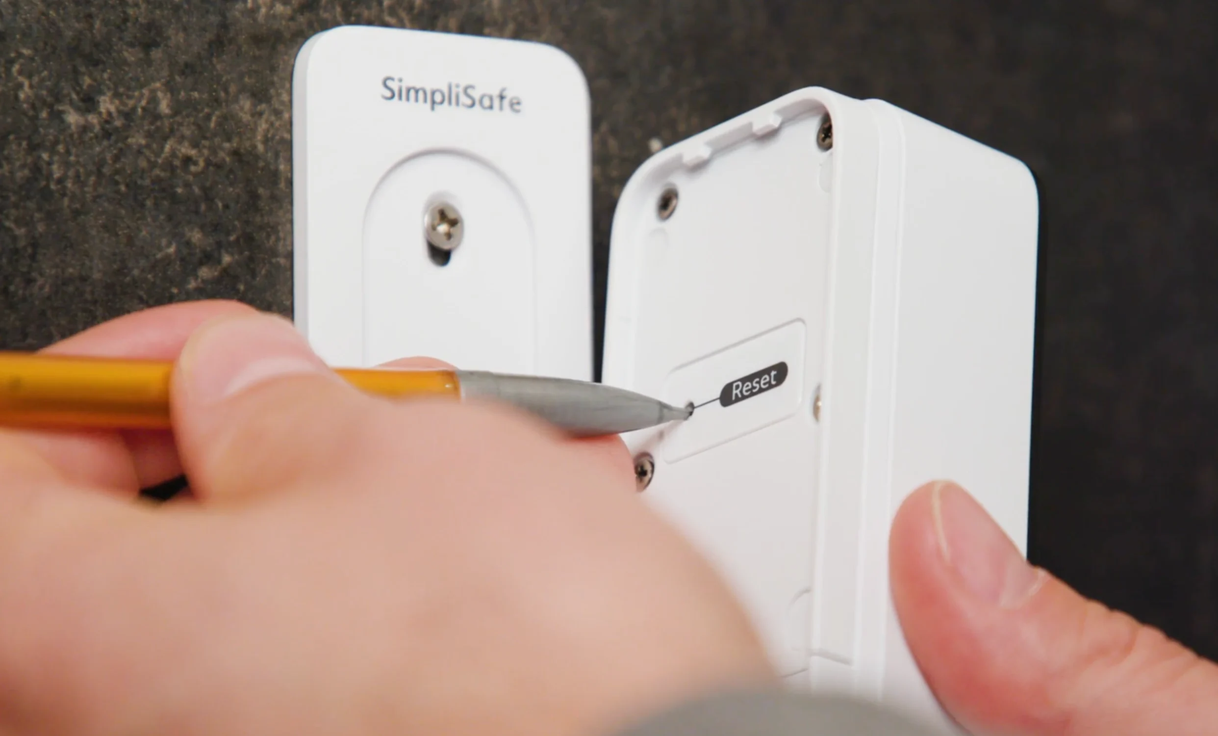 A mechanical pencil being used to press and hold the pinhole button located on the back of the Video Doorbell Series 2.