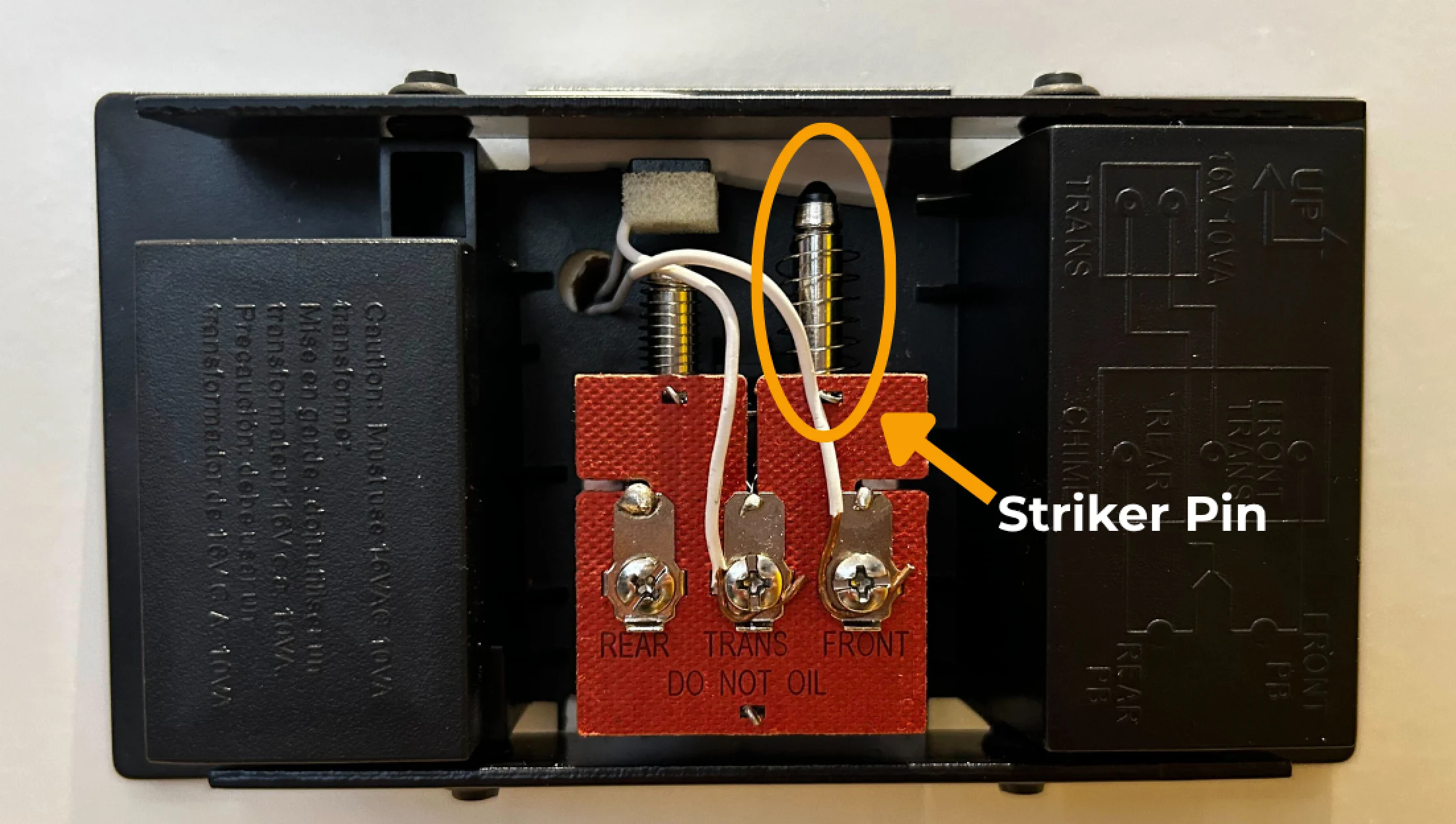 A mechanical chime box, highlighting the device's silver striker pin that physically moves to produce the doorbell's chime.