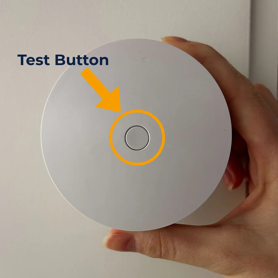 The front face of the Smoke & CO Alarm Listener, with a circle highlighting the Test Button located in the middle of the device.