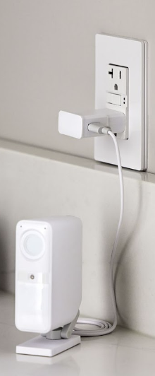  Smart Alarm Indoor Camera plugged into wall outlet on kitchen counter.