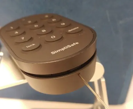 Smart Lock with pinhole key inserted into pinhole at the bottom of the pad.