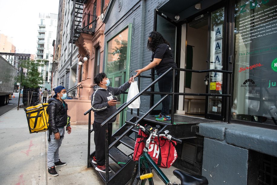 Delivery workers pick up food outside Zuul. Image Source: The Washington Post
