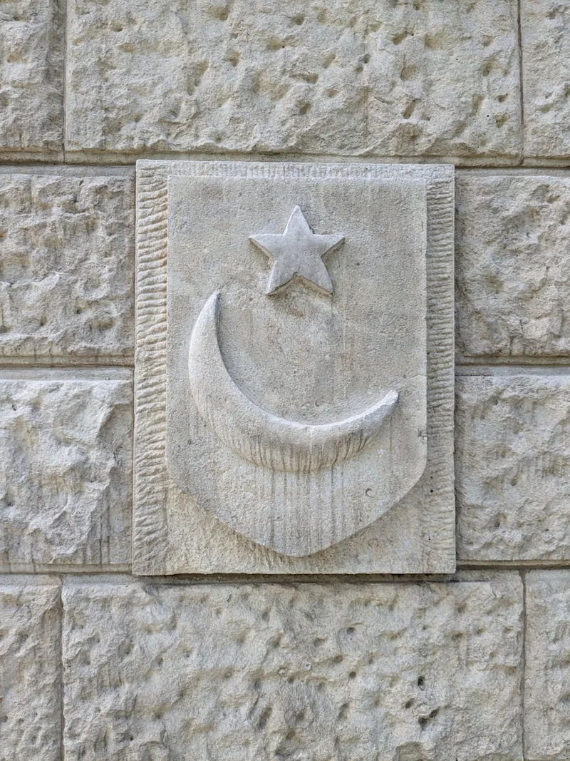 A crescent and star shield carved on the central monument