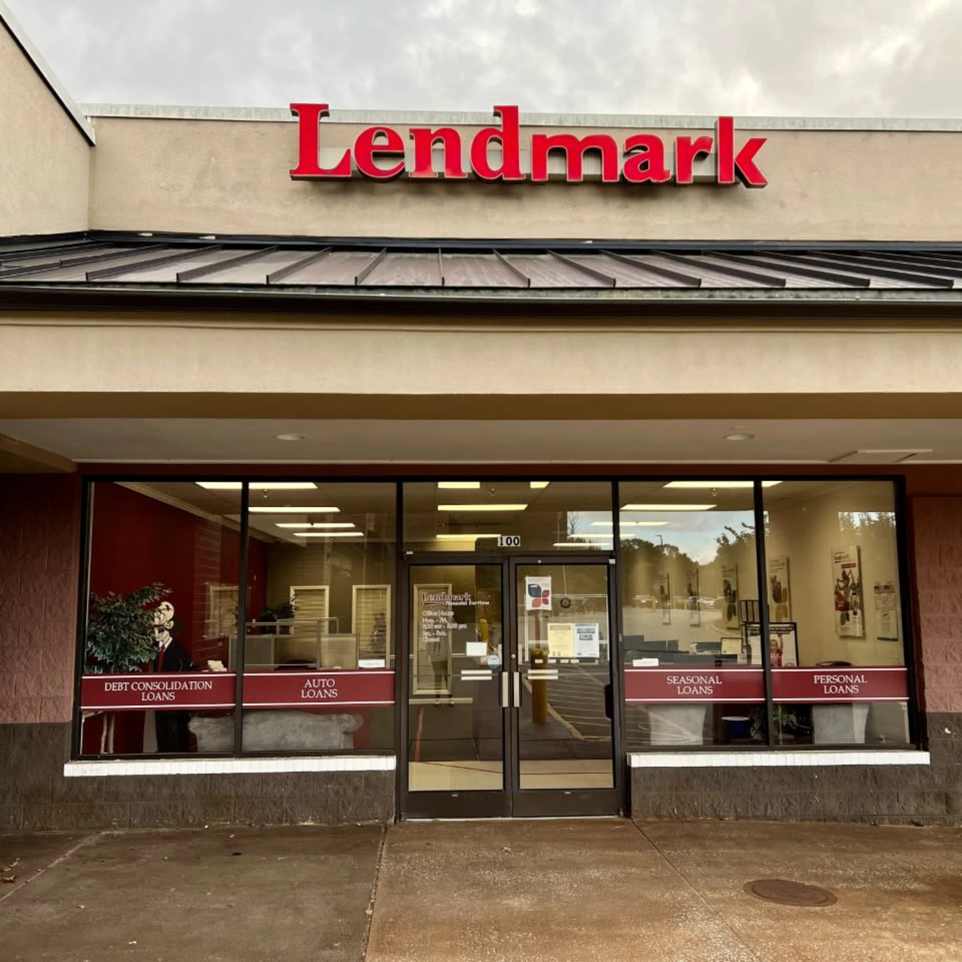 A storefront with large windows and a red "Lendmark" sign above. Loan types like "Auto" and "Personal" are displayed. The setting is clean and inviting.