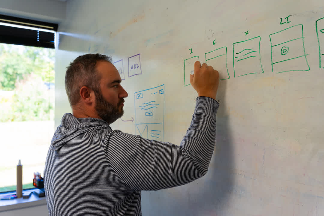 moonello-software-development-services-precision-projects-matt-trueblood-at-whiteboard
