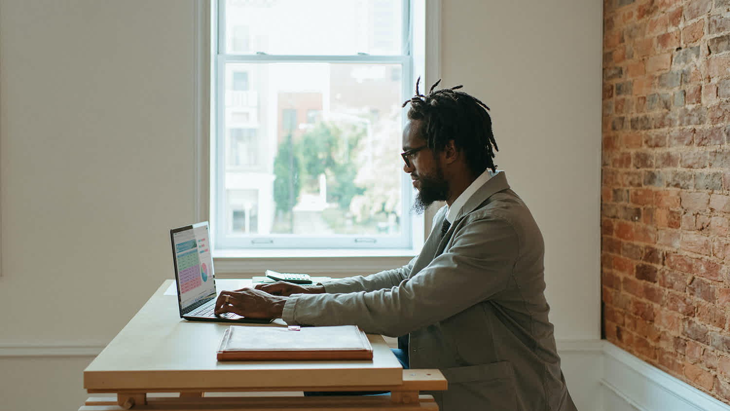 A Person Sitting at a Desk with Laptop and Papers