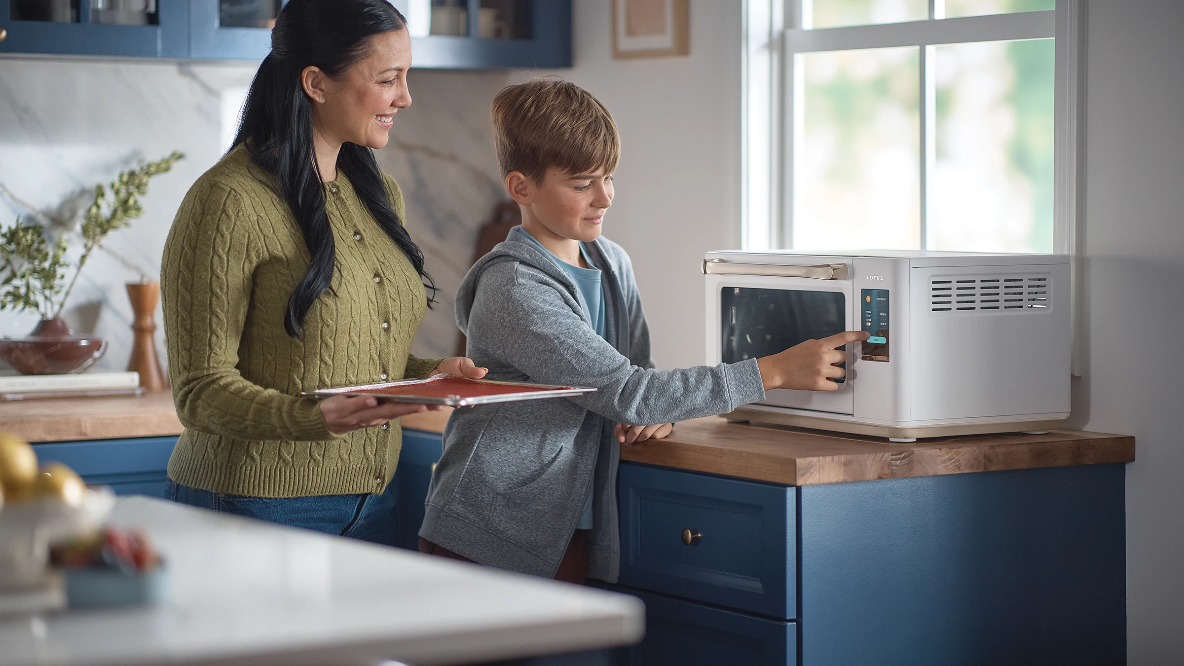 The Luminary oven in Alabaster with a mother and son selecting a cooking mode together