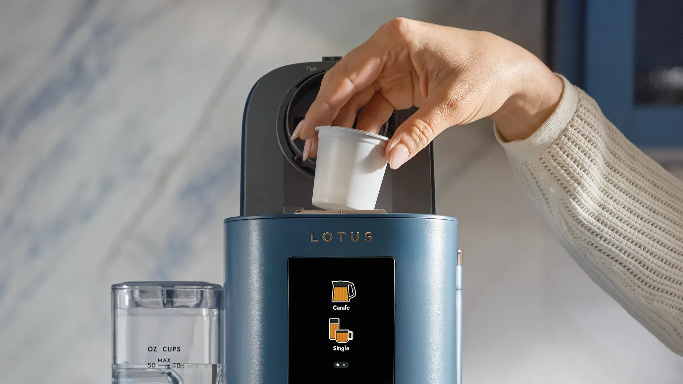 A single-serve coffee pod inserted into the top of The Ritual coffee system in Bluestone