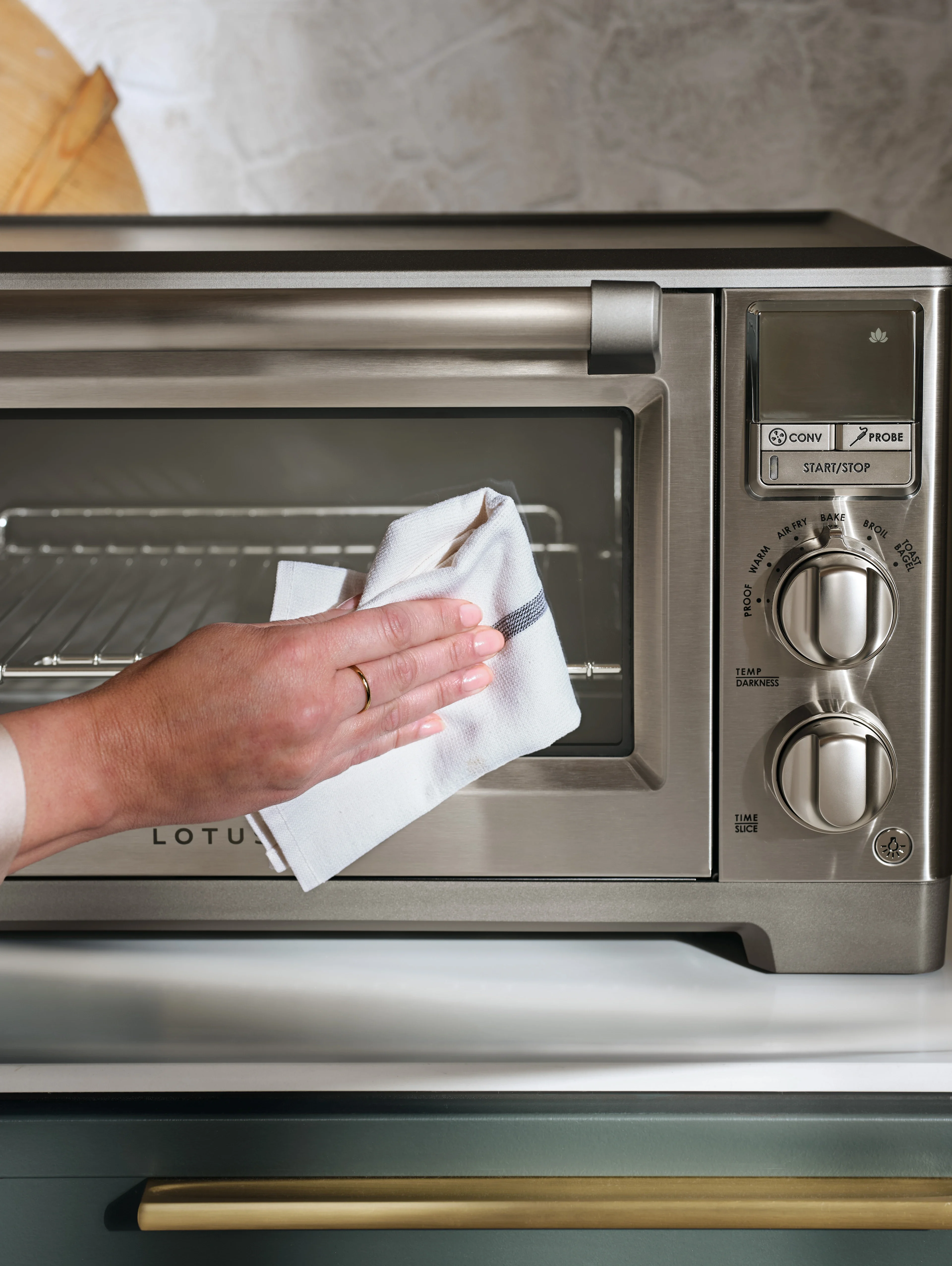 close up of a person cleaning the front of the perfectionist™ air fry and convection oven model ltsco500