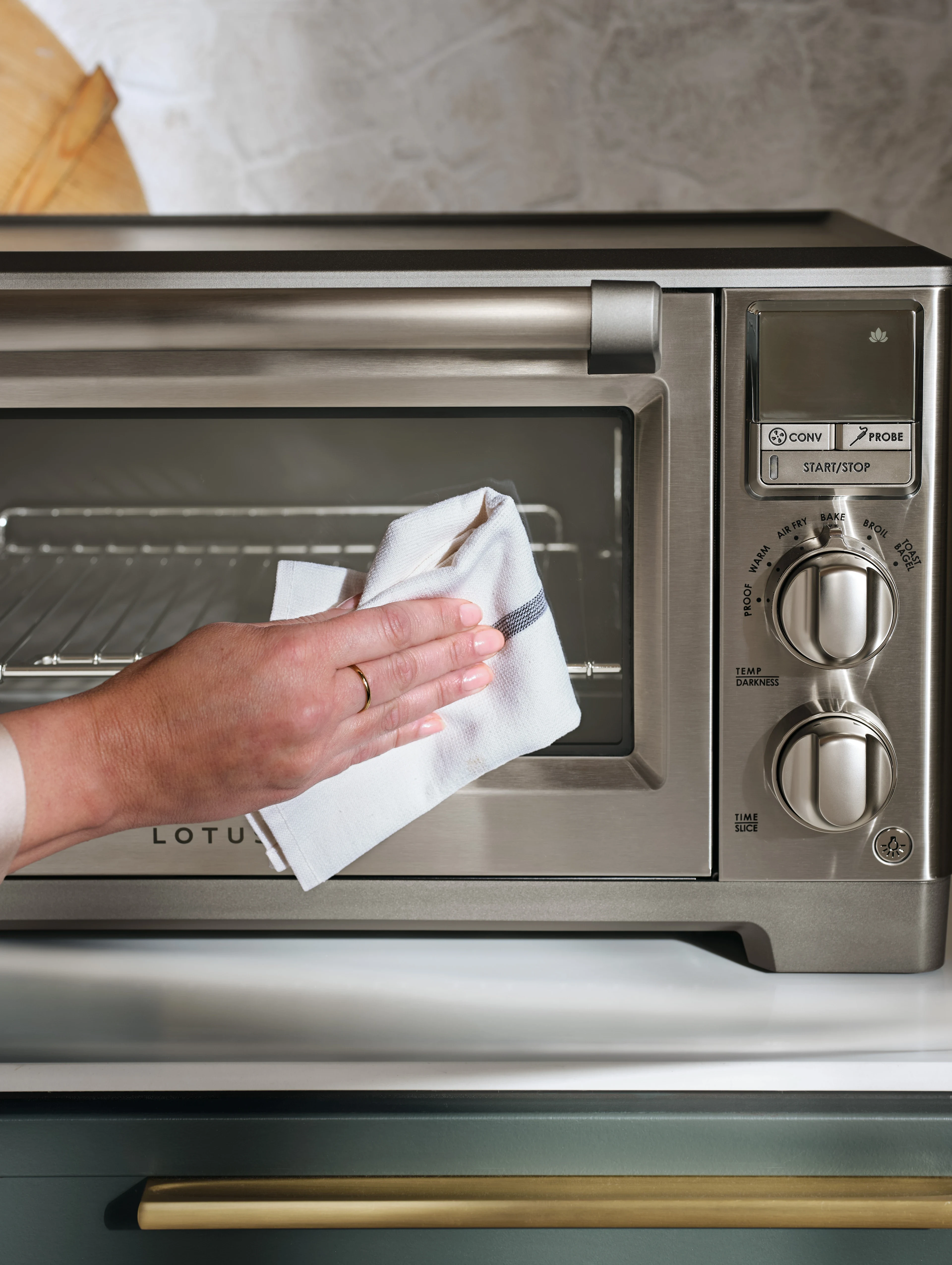 close up of a person cleaning the front of the perfectionist™ air fry and convection oven model ltsco500