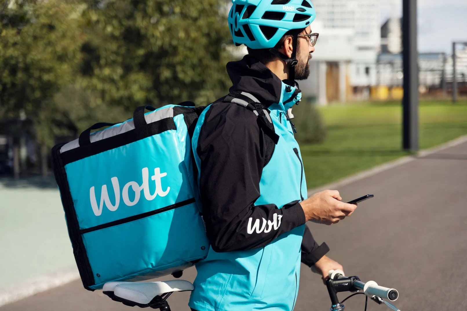 Wolt courier with bike using app