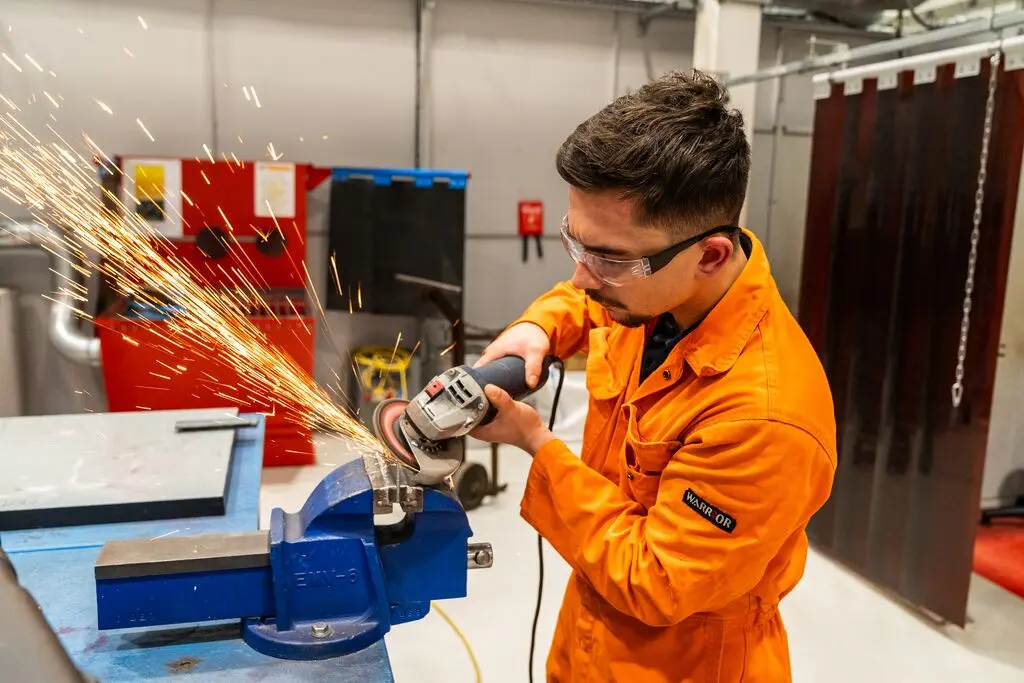 Engineering Apprentice, Ben using grinder at MAKE UK