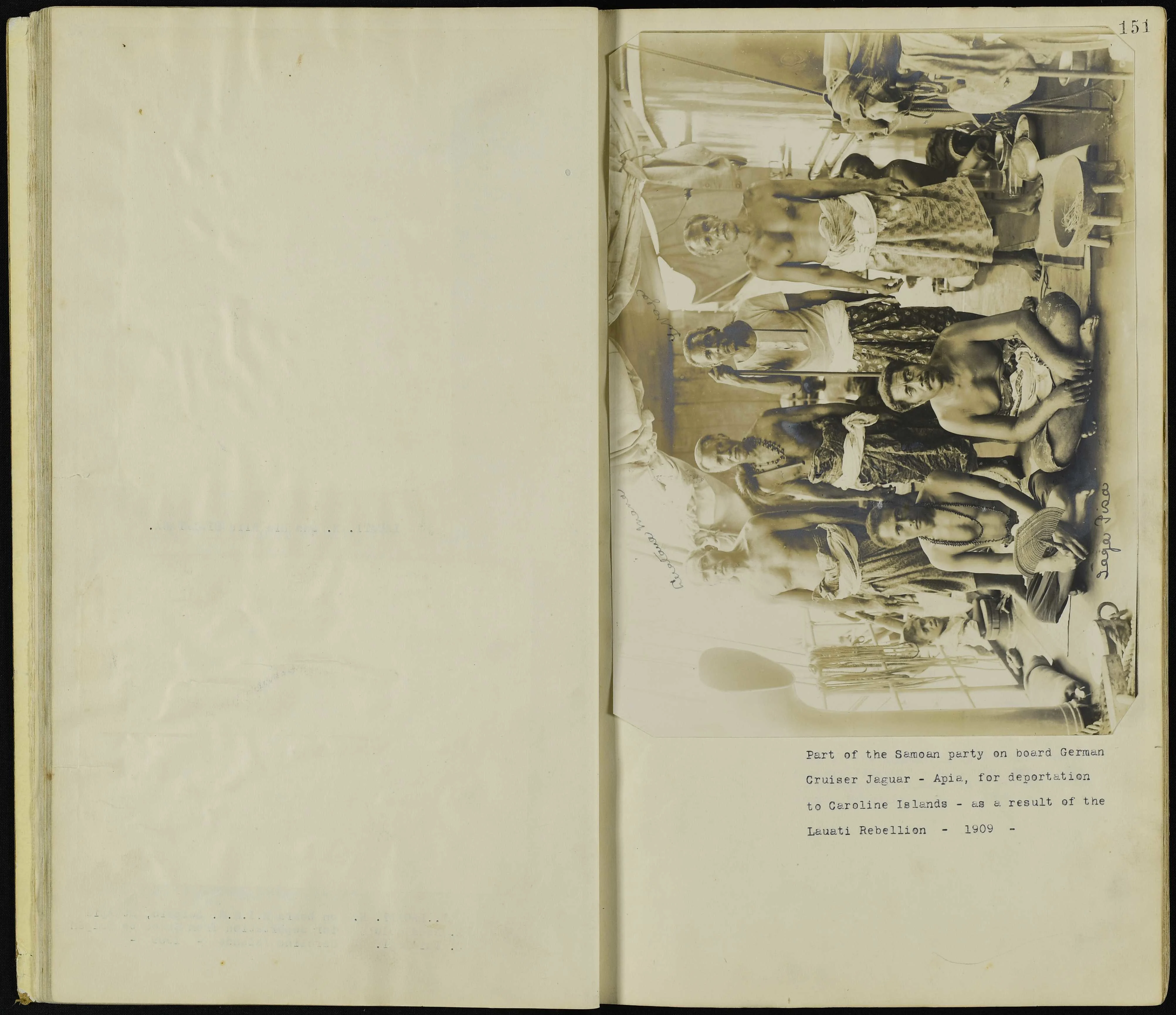 Archival image showing a group of six men in Sāmoan dress. Two are sitting and four are standing. The faces of two more men are visible in the background.