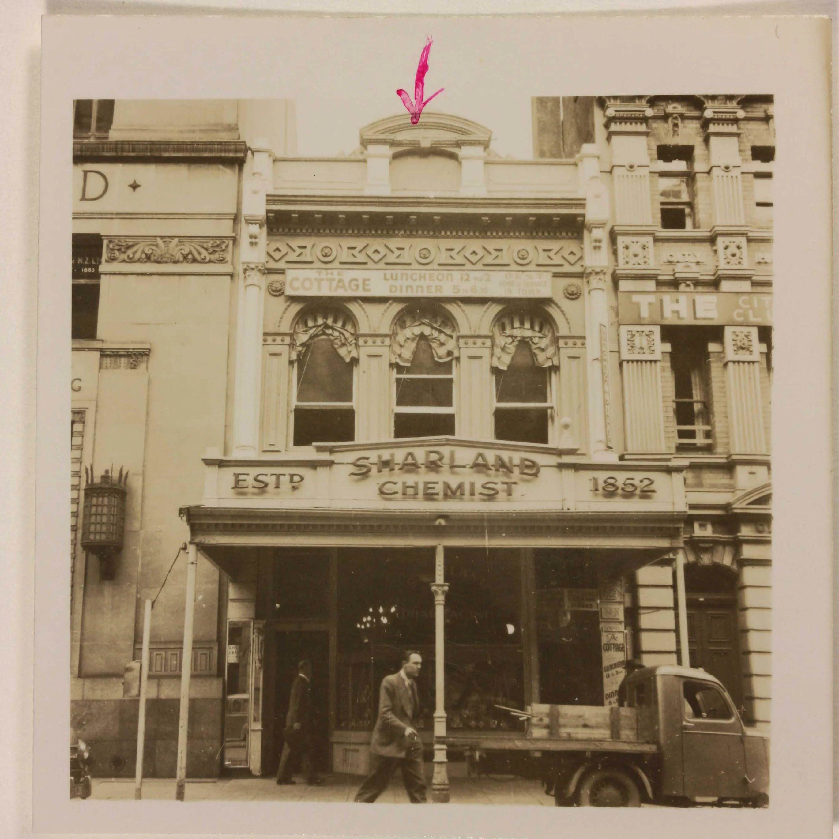 A sepia photo showing Sharland's Chemists from the road