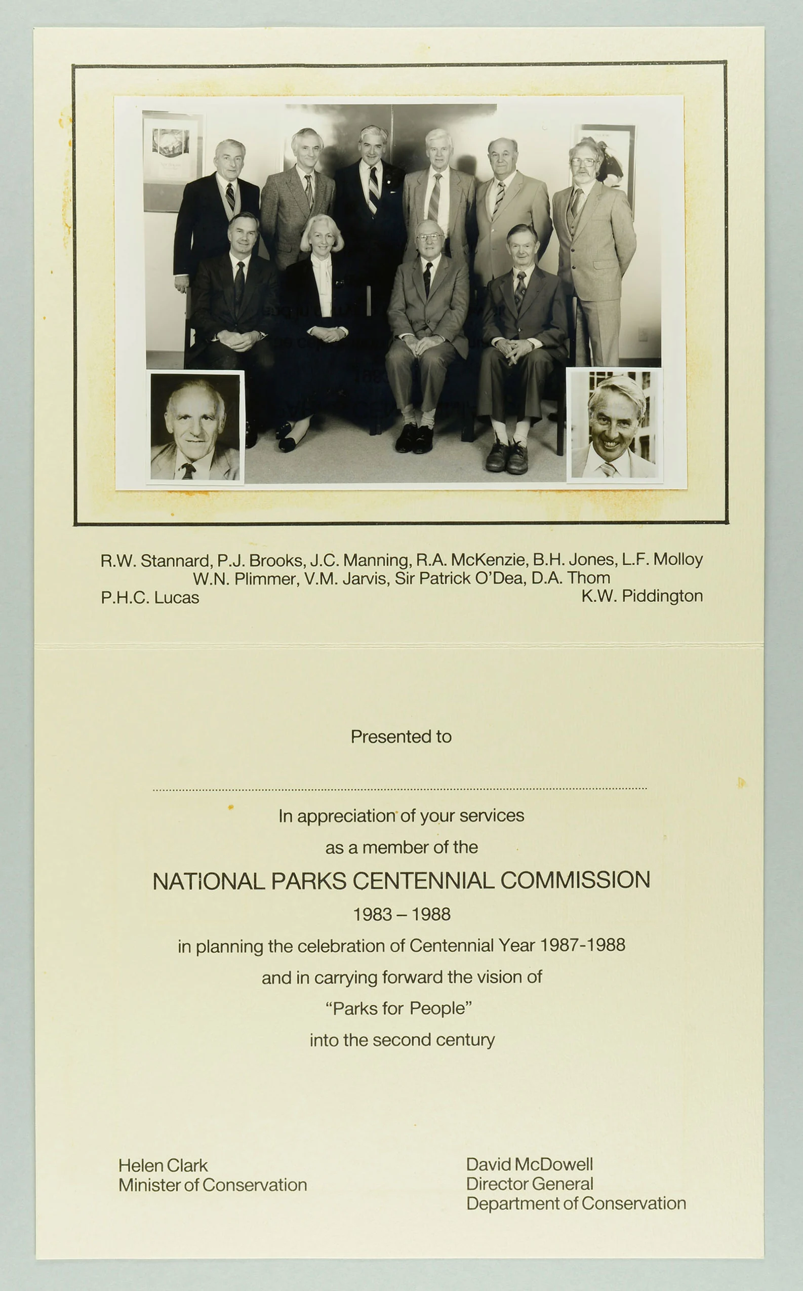 An old black and white photo of a group people on top of a paper and some text below 