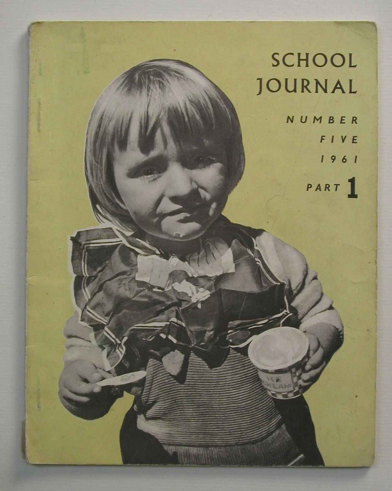 Black and white photo of a young girl holding an ice cream cup and spoon on a pale yellow background