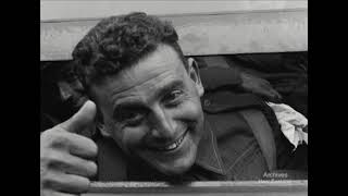 A still from 'Country Lads'. A man smiles and gives the thumbs up.