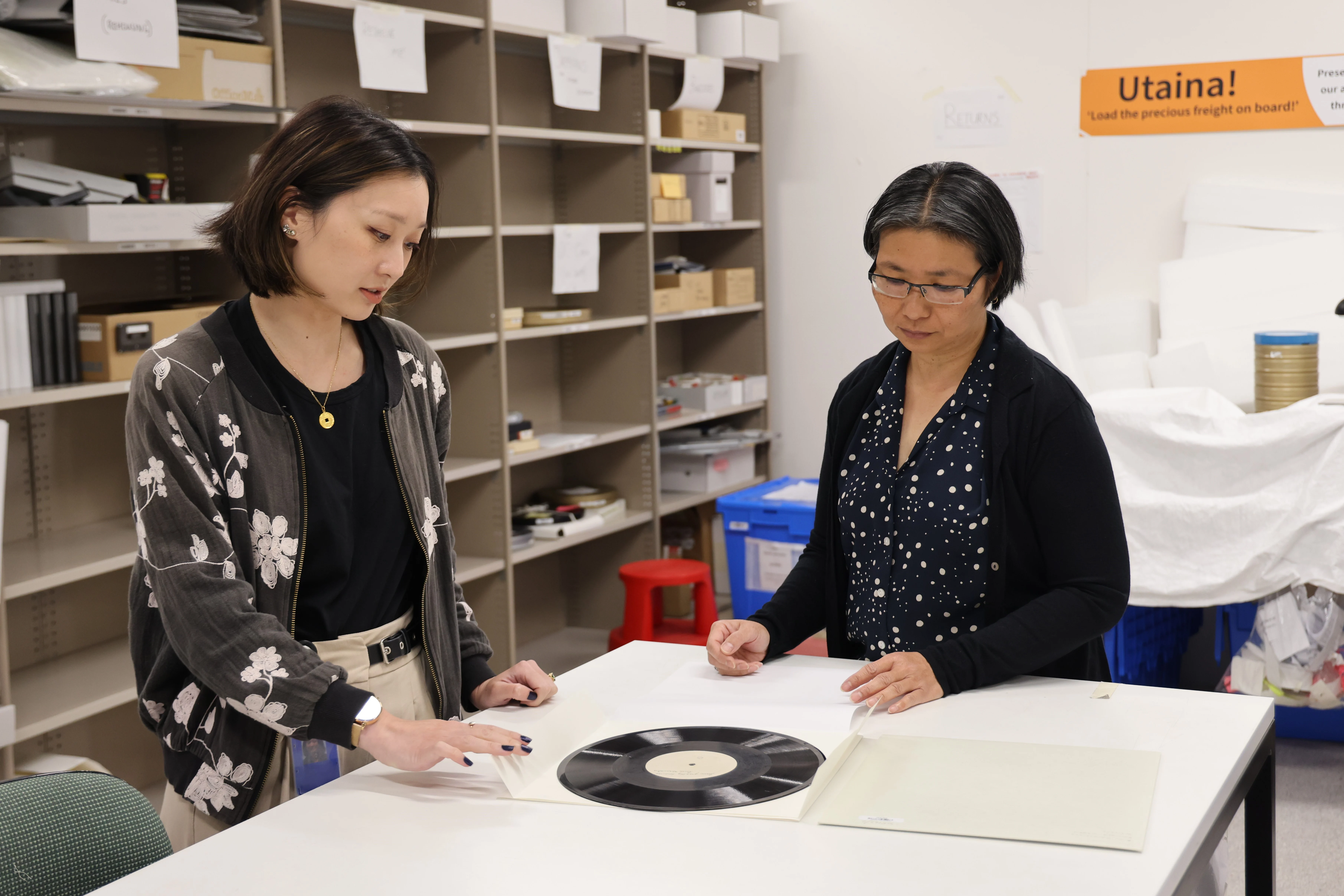 2 people looking at a vinyl record.