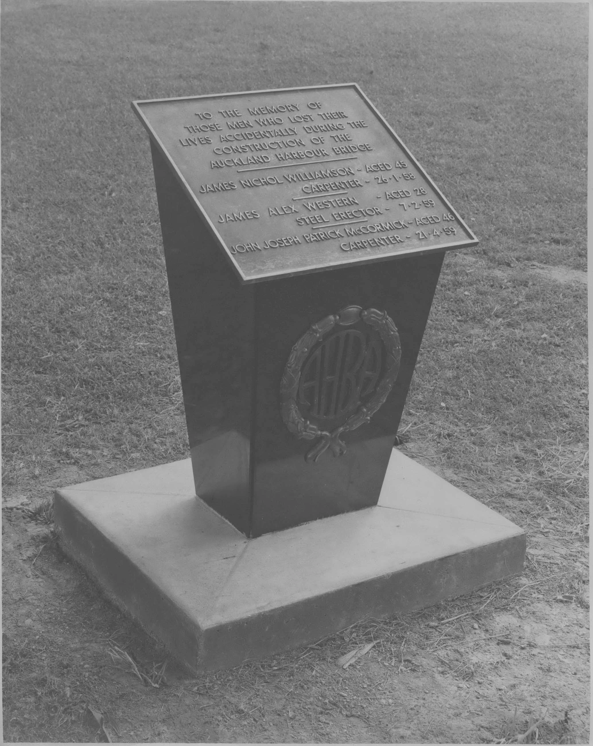 Black and white photo of the plaque remembering the three men who died during construction of the Bridge.