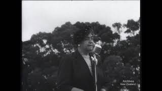 Black and white photo of a man wearing a black jacket with trees in the background