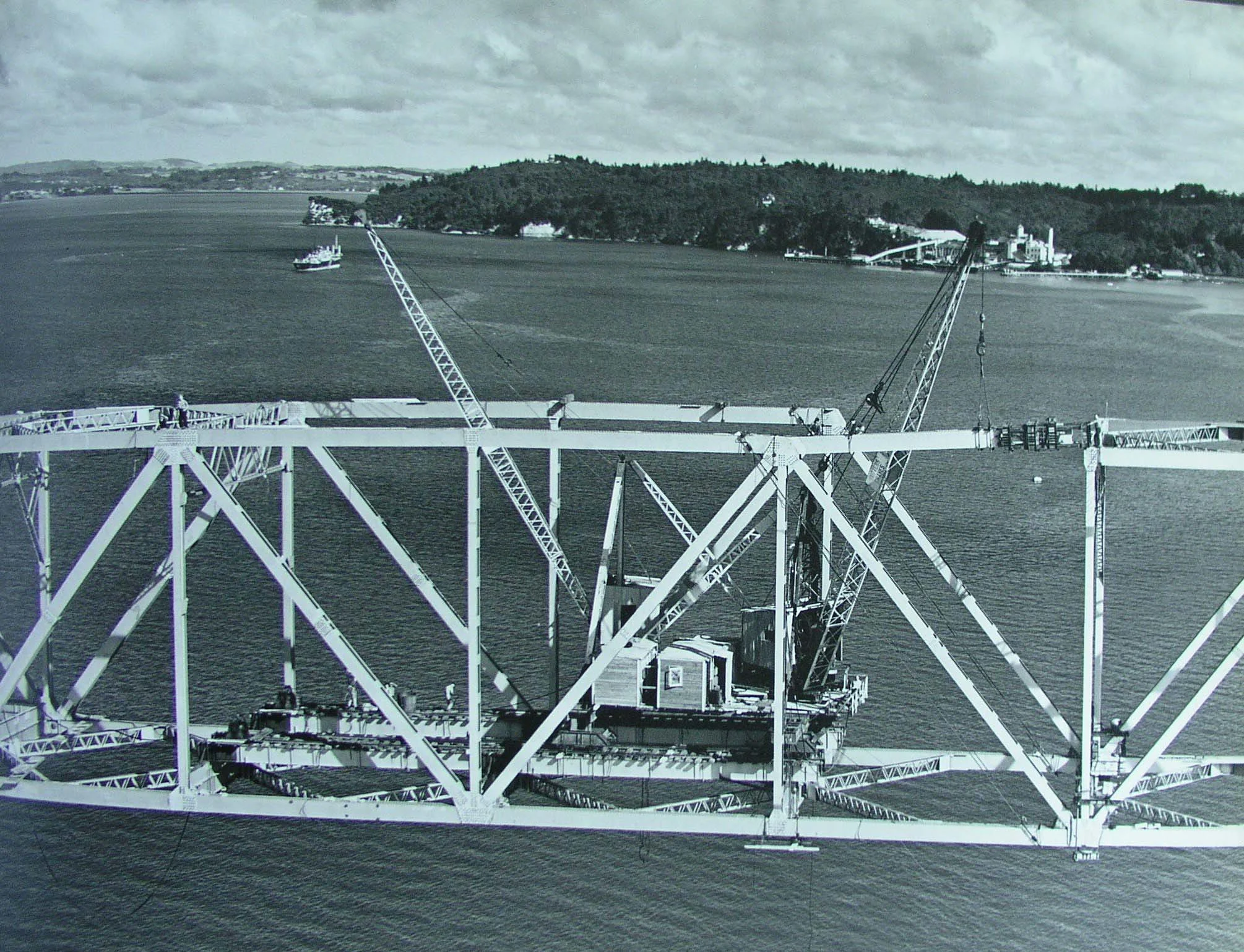 Aerial photo showing construction of Auckland Harbour Bridge on 9 March 1959. Girders being lifted.