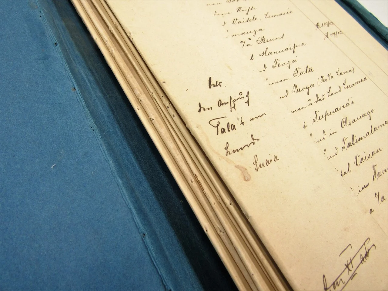 Photograph of pages the bound spine of an old register with hand written script 