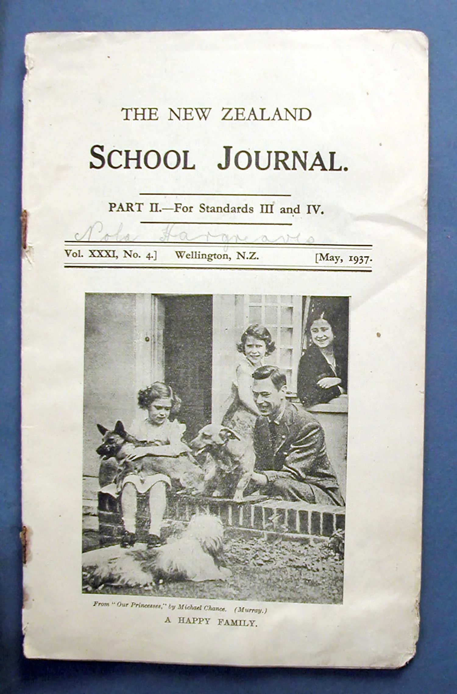 Black and white photo of a family with dad, mum, 2 girls and 3 dogs on an old yellowed paper