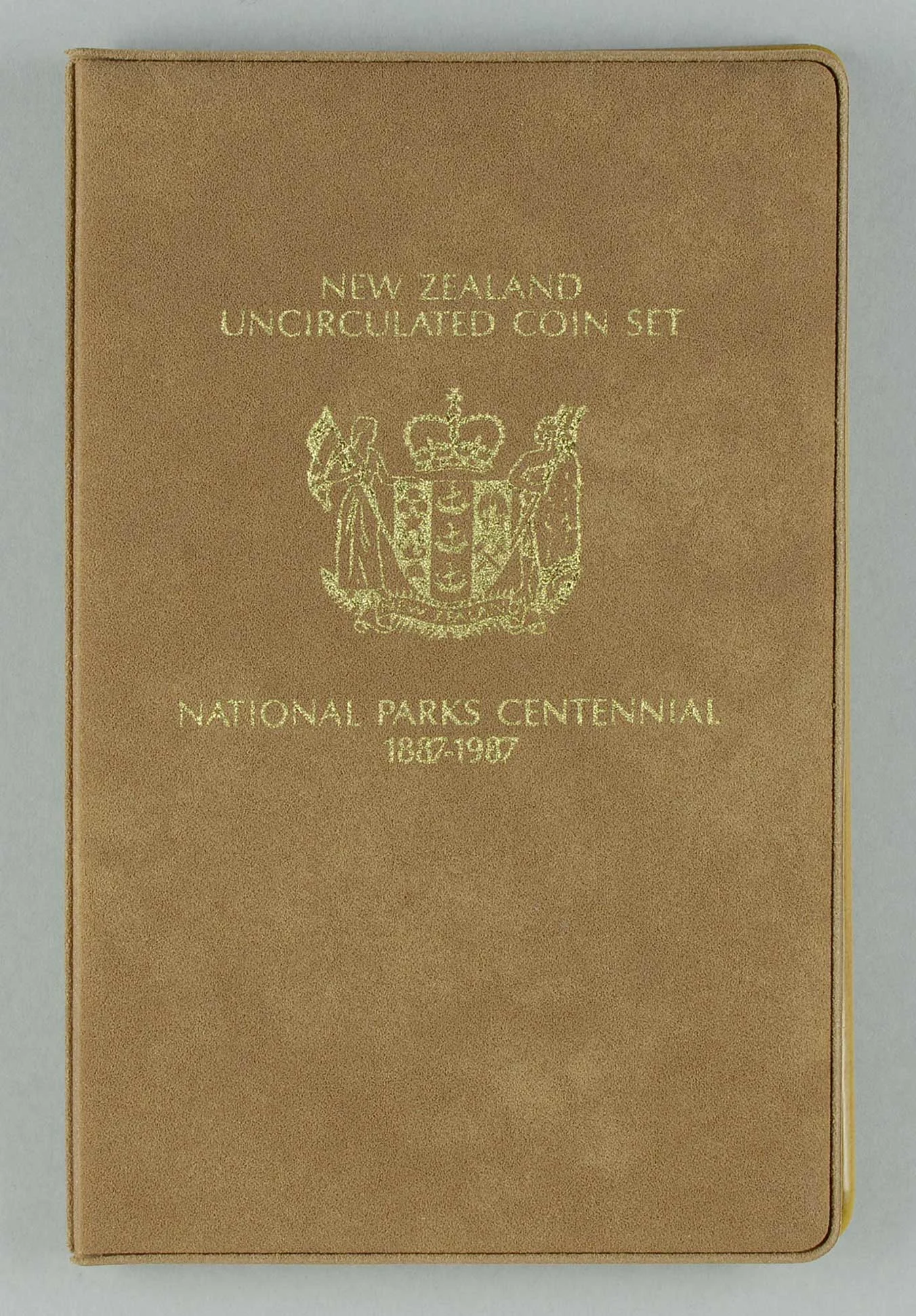 A light brown bool with some text and a logo in golden colour